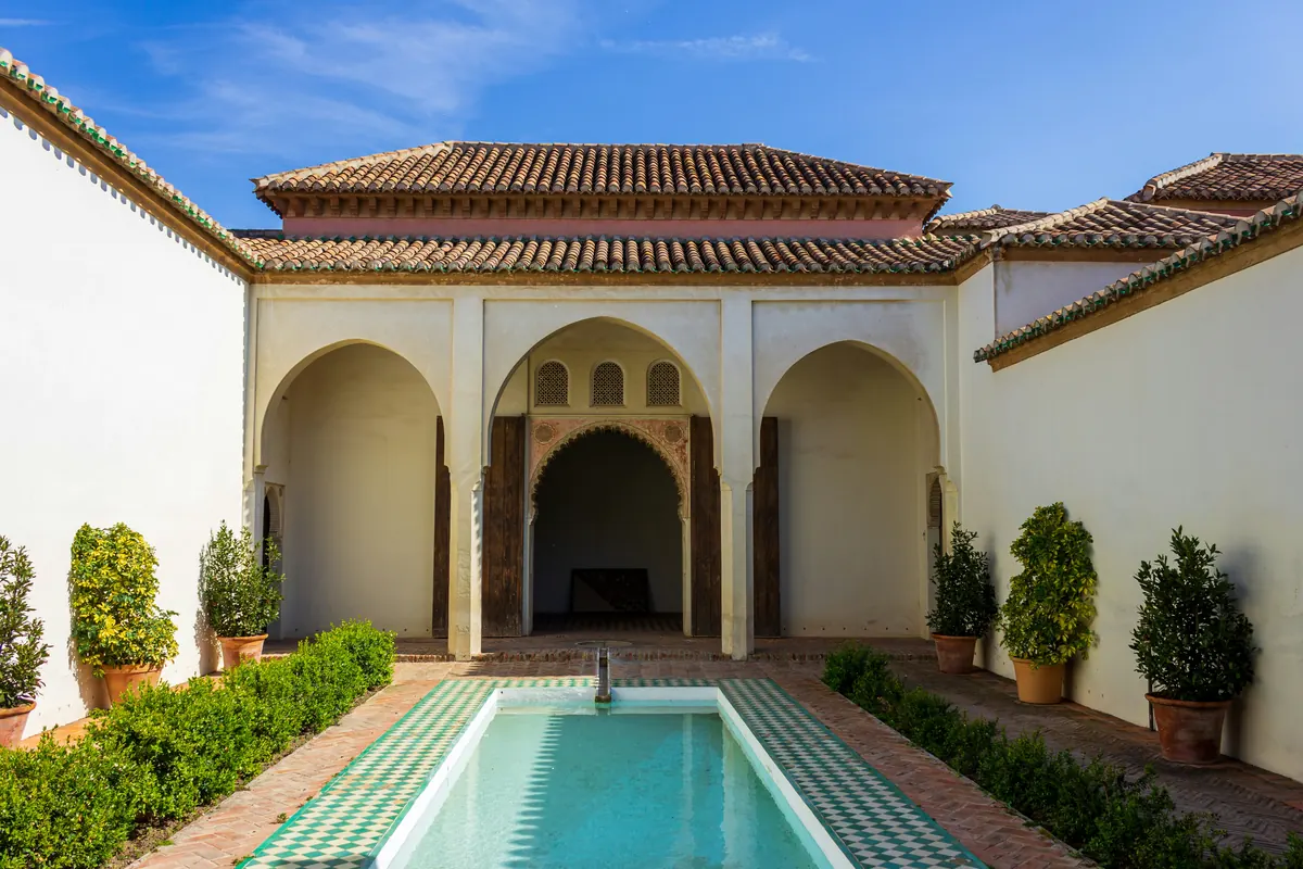 Quiet Andalusian patio in Malaga with arches and a reflecting pool